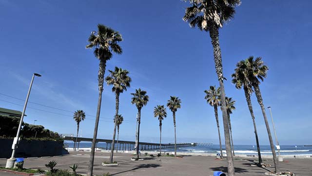 The Ocean Beach Pier parking lot, normally full on a spring day, remains empty.