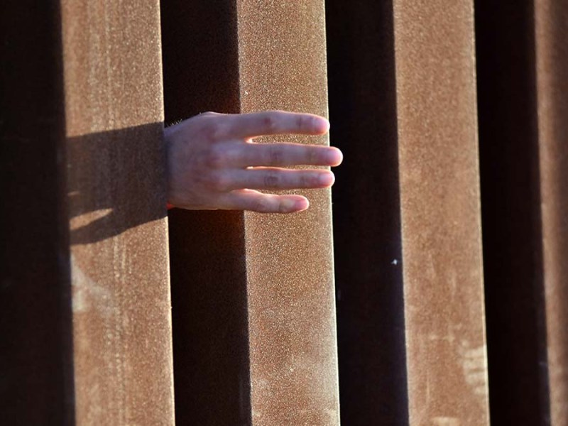 A migrant reaches out for a blanket. Photo by Chris Stone