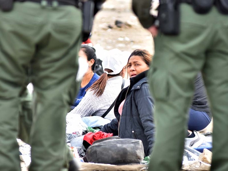 A wan waits alongside Border Patrol agents. Photo by Chris Stone