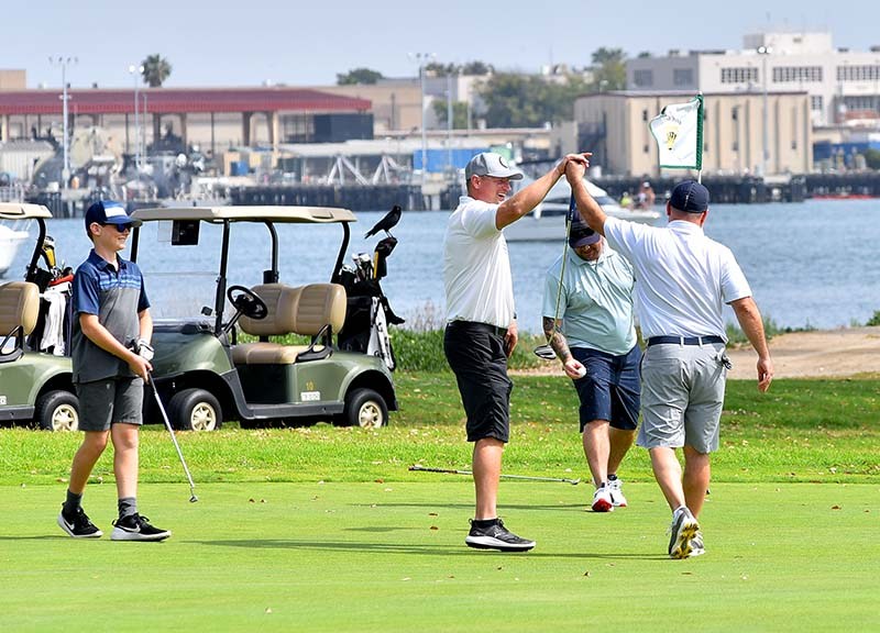 Golfers in foursome at the Coronado municipal course high-five after finishing play over the weekend — the first time they could play in weeks.