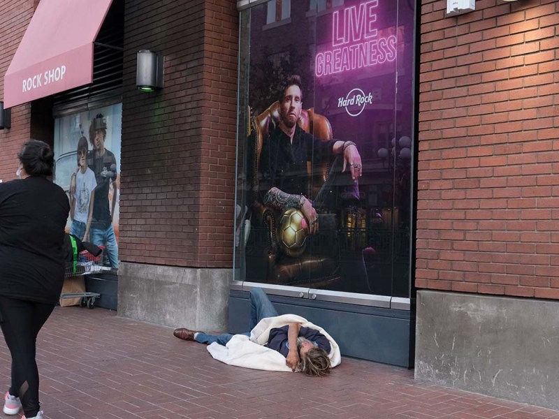 A homeless man sleeps in the Gaslamp Quarter of San Diego. Photo by Chris Stone