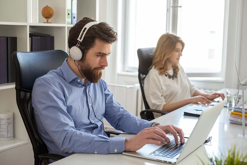Man-With-Headphones-Working-On-Laptop-Next-To-Colleague-how-to-find-your-niche