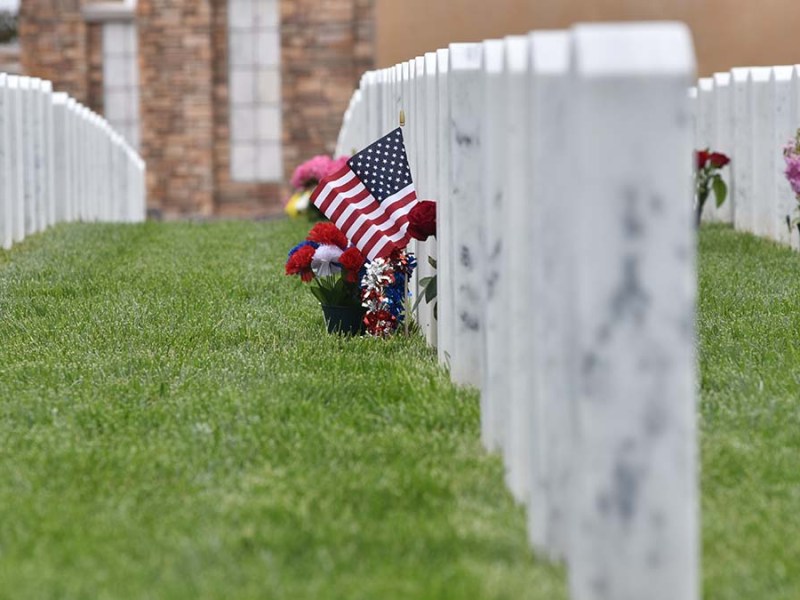 Families add flags to headstones at Miramar National Cemetery. Photo by Chris Stone