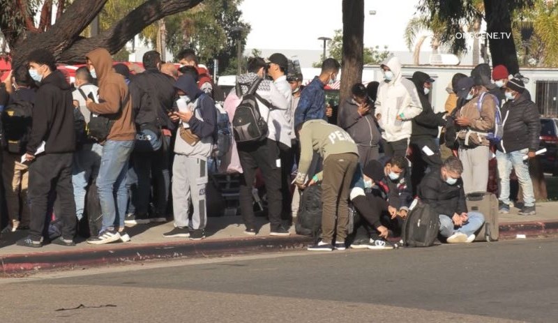 Asylum-seekers and refugees wait for information from volunteer groups after being dropped off by Border Patrol at the Iris Avenue Transit Center in San Ysidro. Courtesy Onscene.TV