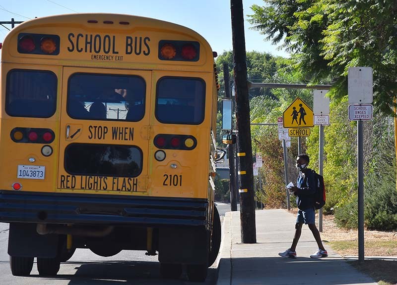 A student gets on a bus after attending a two-hour in school session at Lafayette Elementary School in Clairemont.