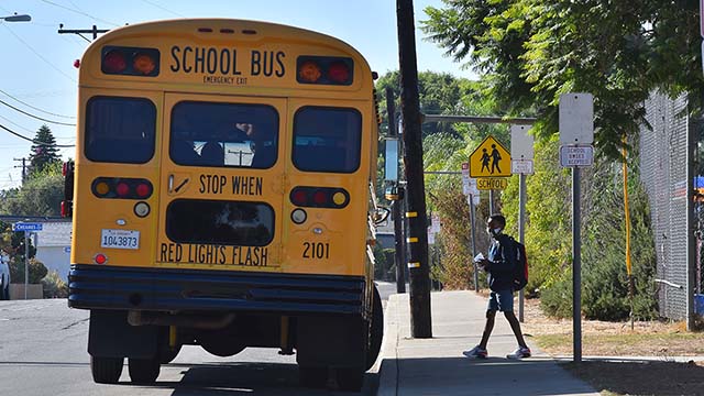 A student gets on a bus after attending a two-hour in school session at Lafayette Elementary School in Clairemont.