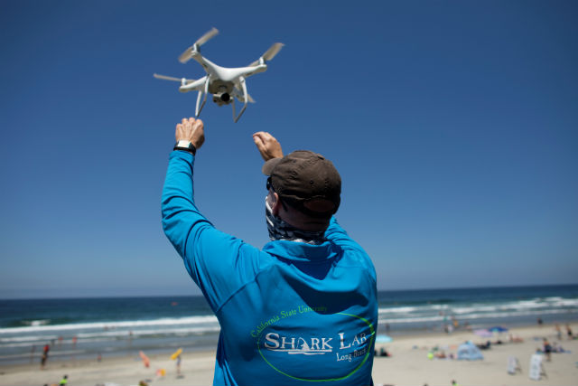 A researcher retrieves an incoming drone